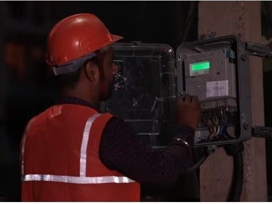 Technician in safety gear installing a smart prepaid meter