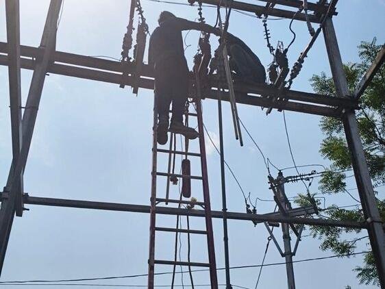 Workers on a ladder carrying out electrical structure work at height